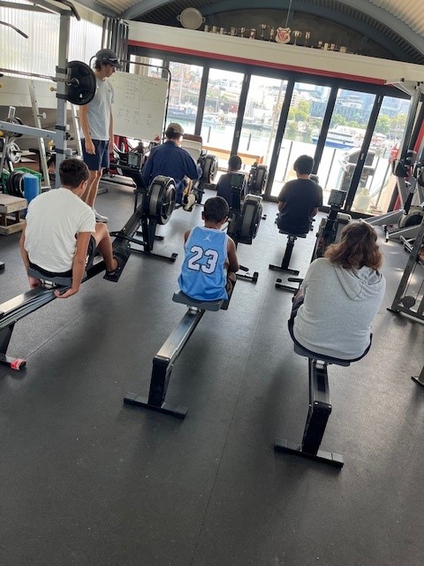 Three boys using rowing machines