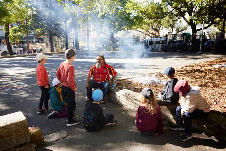 Uncle Les conducting a smoking ceremony while talking to Glebe Public School Students Photograph: Tom Psomotragos
