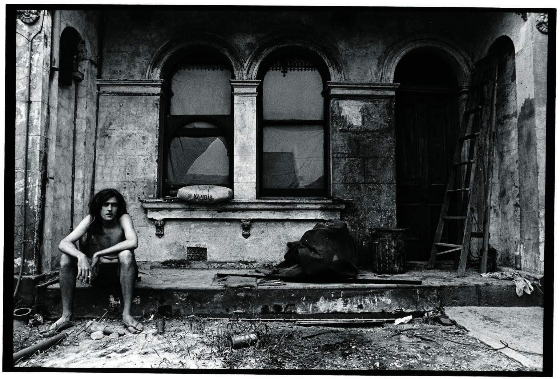 Man on front porch of dilapidated house in Glebe, 1973. Source: City of Sydney Archives. Photographer: Leon Gregory